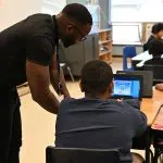 A teacher and studen using a laptop to access christian virtual education