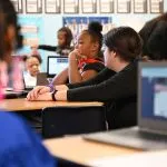 A classroom of students using online live classes