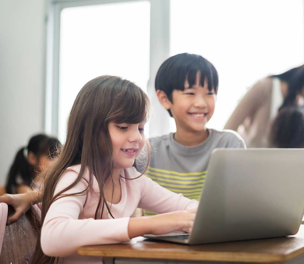 Several students working together and using one laptop for our christian virtual education